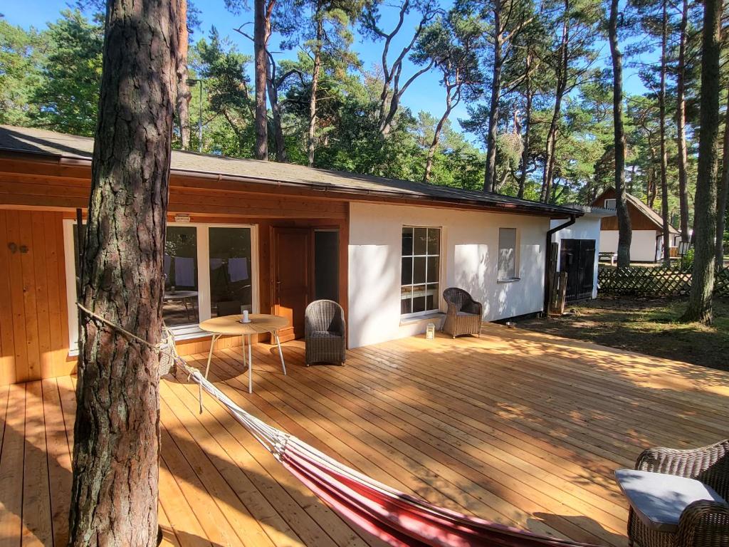 a hammock on a deck in front of a house at Beachbungalow in Karlshagen