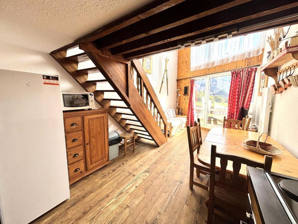 une cuisine et une salle à manger avec une table et un réfrigérateur dans l'établissement Résidence Grande Masse - Duplex mezzanine 8 personnes aux Ménuires MAE-4384, aux Menuires