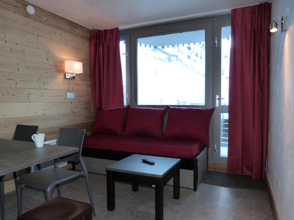 un salon avec un canapé rouge et une table dans l'établissement Résidence Diamant - Studio pour 4 Personnes 184, à Aime La Plagne