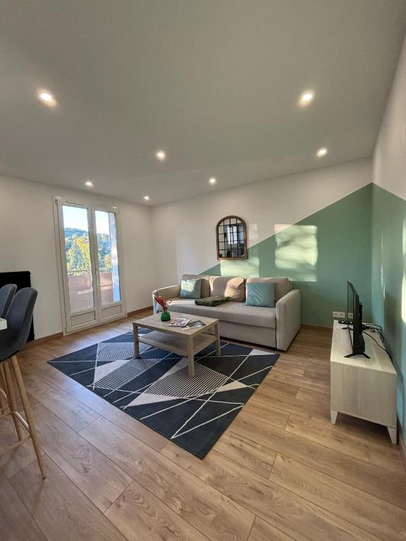 un salon avec un canapé et une table dans l'établissement Appartement 1 chambre à Thionville proche Luxembourg, à Thionville