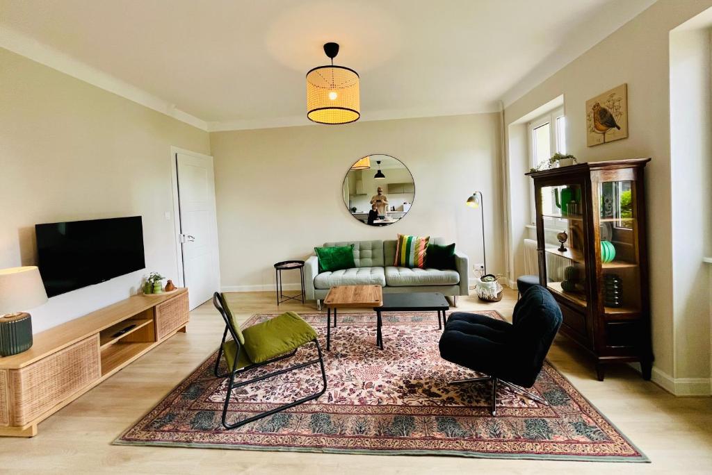 ein Wohnzimmer mit Sofa und Fernseher in der Unterkunft Chez Jean ! Au pied du vignoble, à 5 min de Colmar in Ingersheim