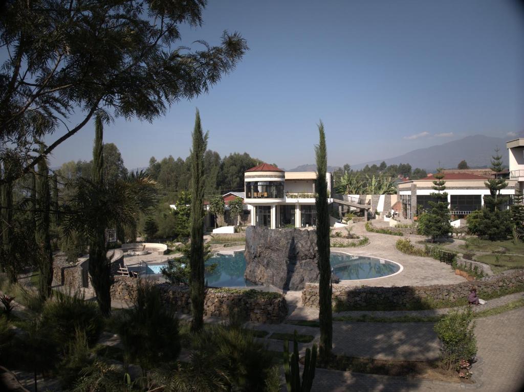 une maison avec une piscine dans un jardin dans l'établissement Grotta Resort, à Gasanze
