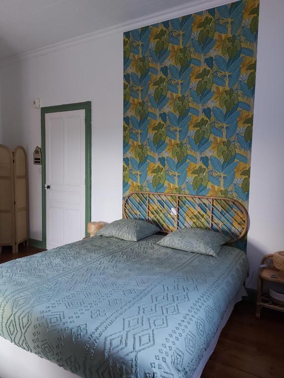 une chambre avec un lit avec une couette bleue dans l'établissement La Tuilerie, à Barcelonne-du-Gers