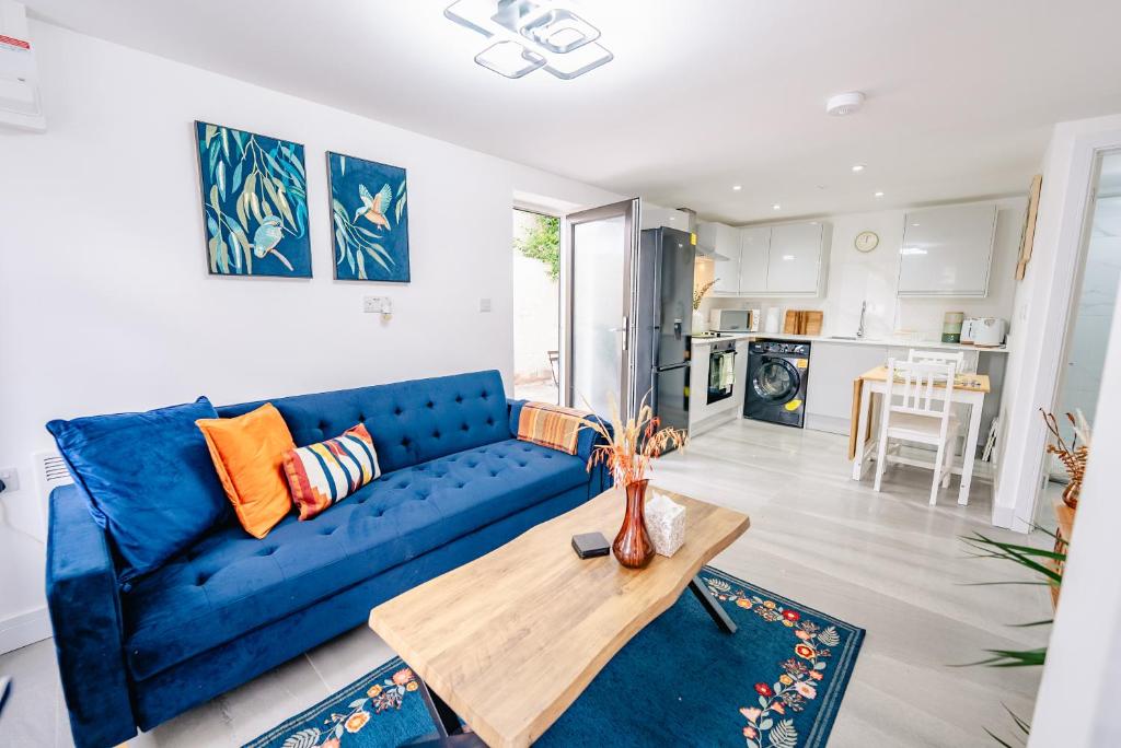 a living room with a blue couch and a table at Amias Homes in Cardiff
