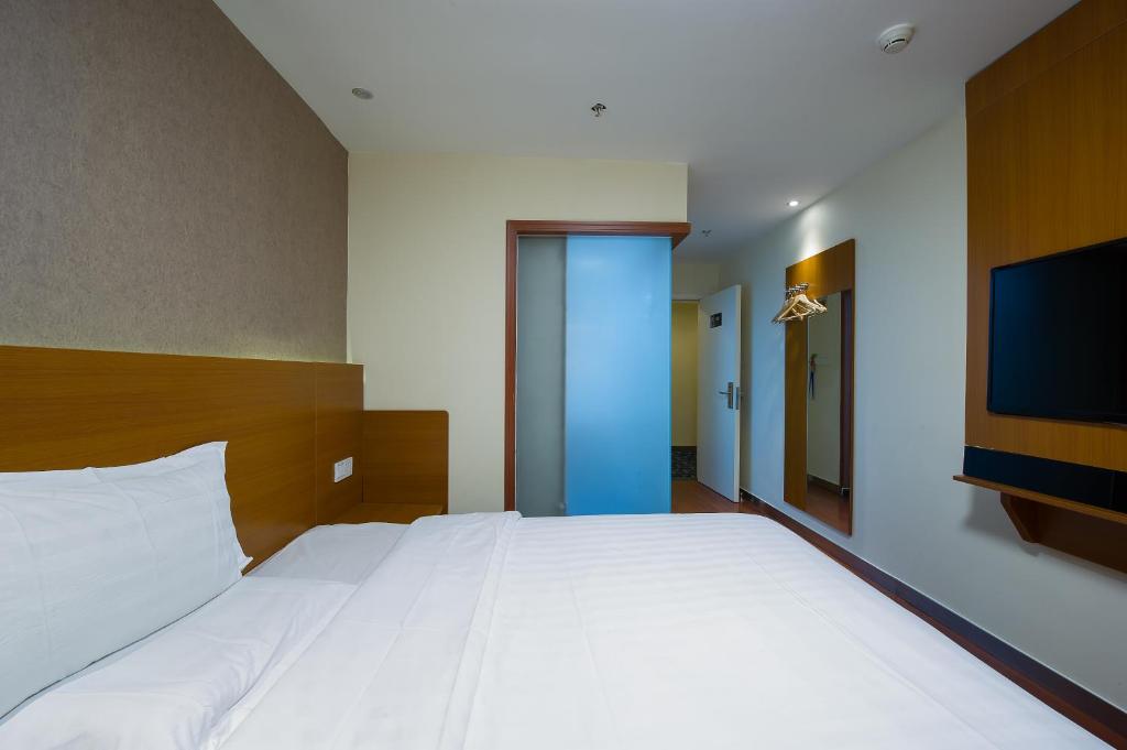 a bedroom with a large bed and a flat screen tv at 7Days Premium Guilin Seven star International Exhibition Center in Guilin
