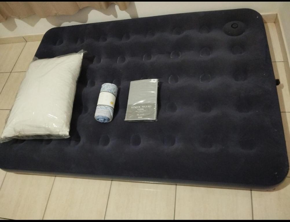 a black tray with two items on top of a bed at Casa com ar condicionado, próximo ao Atacadão in Ji-Paraná
