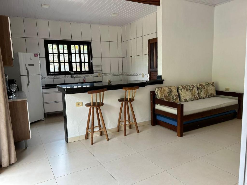 een keuken met een aanrecht en krukken in een kamer bij Cantinho da serra in Ubatuba