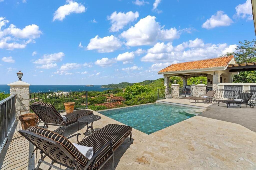 a swimming pool with chairs and a gazebo at Luxurious 3 Bedroom Villa in Coco