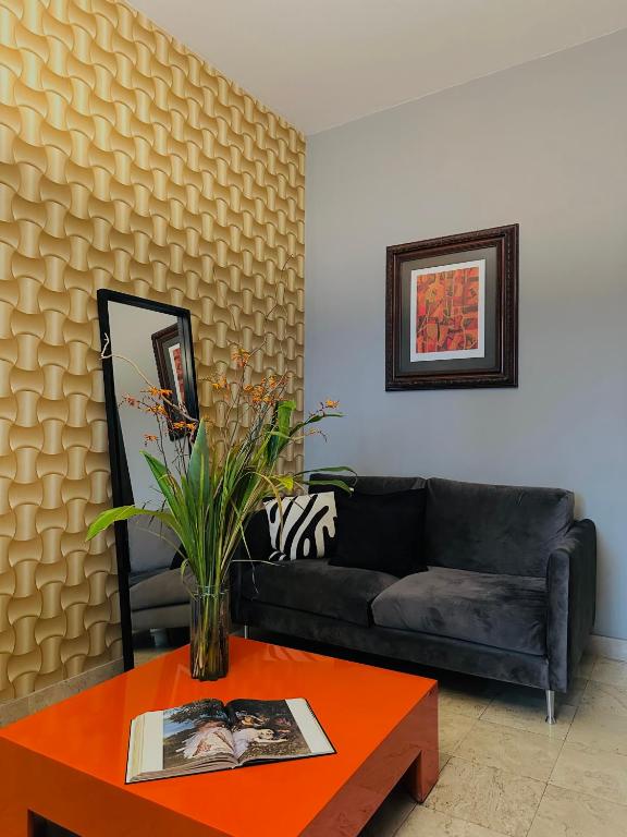 A velvet sofa and bright coffee table create a compact, art-filled sitting corner.