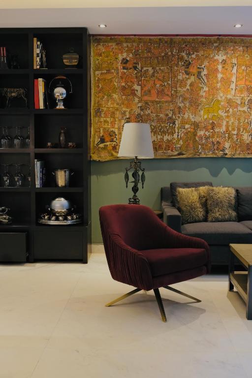 A close view of an art-filled lounge corner with a red armchair and sofa.