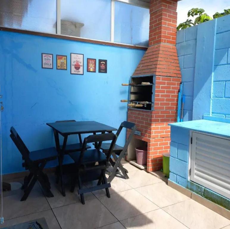 a table and chairs in front of a blue wall at casa itanhaém in Itanhaém