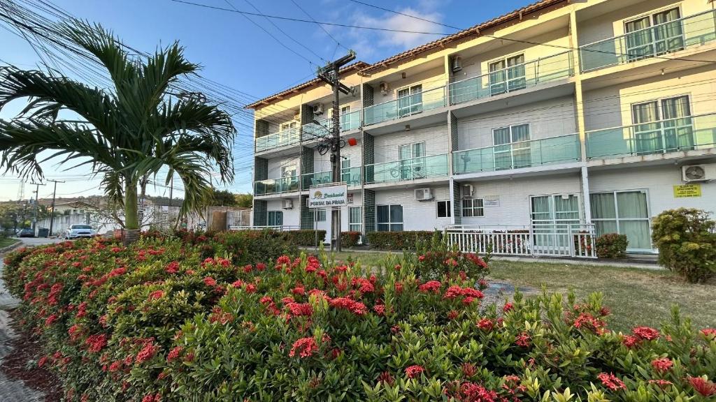 a building with a flower garden in front of it at Flats Duplex Super Aconchegantes e Confortáveis in Maragogi