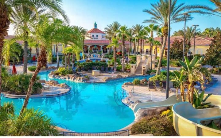 a resort with a large pool with palm trees at Charming & Cozy Getaway! Lazy River! in Davenport