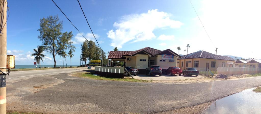 una casa con auto parcheggiate sul lato della strada di Semarak Beach Inn a Dungun