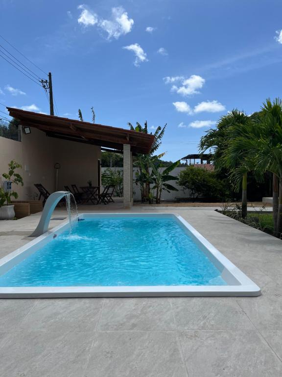 a swimming pool with a water slide in a yard at Granja Raio de Luz in Igarassu