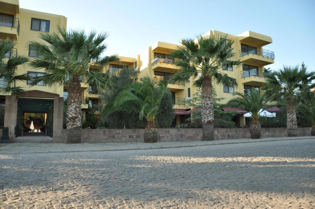 a row of palm trees in front of a building at Palm Court Suites in Ayvalık