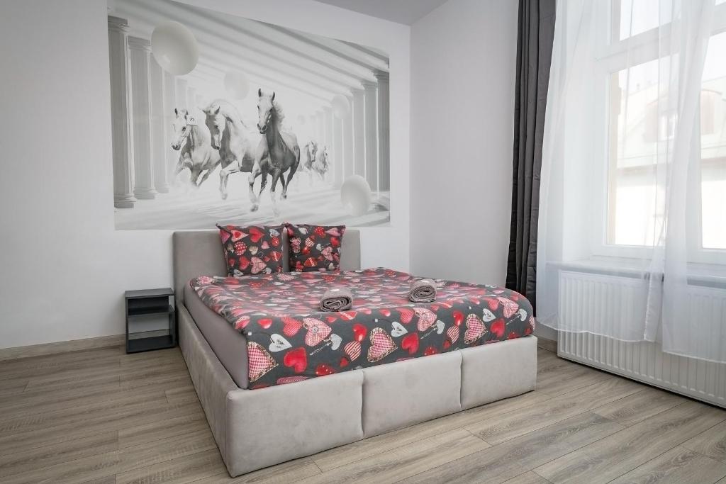een slaapkamer met een bed en een schilderij van paarden aan de muur bij 70s Business Room in Krakau