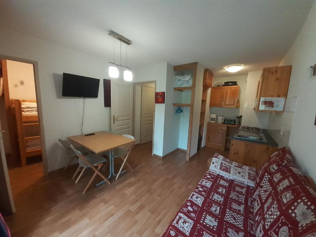 Cette petite chambre comprend une cuisine, une table et un lit. dans l'établissement Confortable Studio-Cabine à Valfréjus avec Wifi et Animaux admis - FR-1-561-127, à Modane