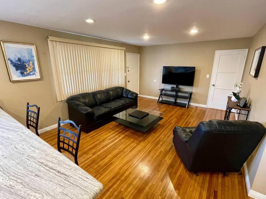 a living room with a couch and a flat screen tv at Entire Urban House Getaway Newly Remodeled in El Monte