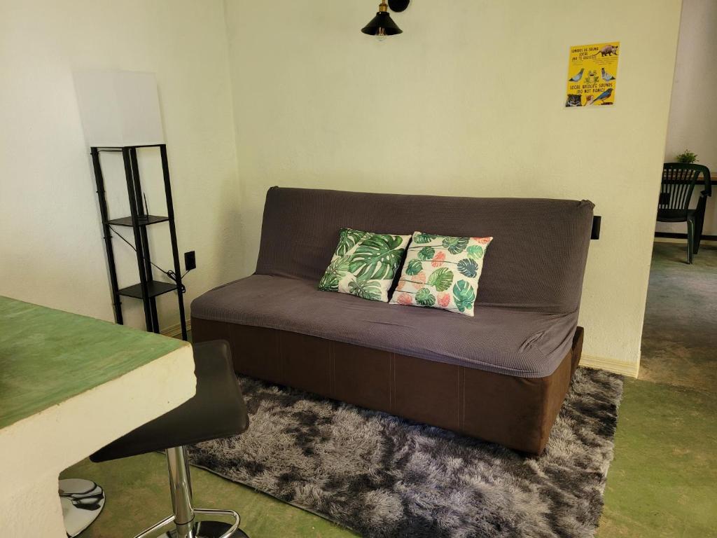 a couch with two pillows on it in a room at Departamento Miguel Angel in Oaxaca City