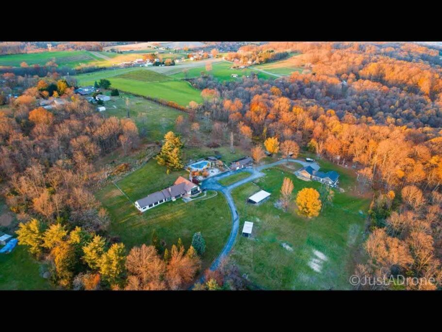 an aerial view of a house in a forest at Villa on a hill with indoor heated salt water pool in Boyertown