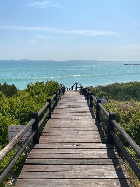 a wooden boardwalk leading to the ocean on a beach at Barefoot at Calypso Beach in Langebaan