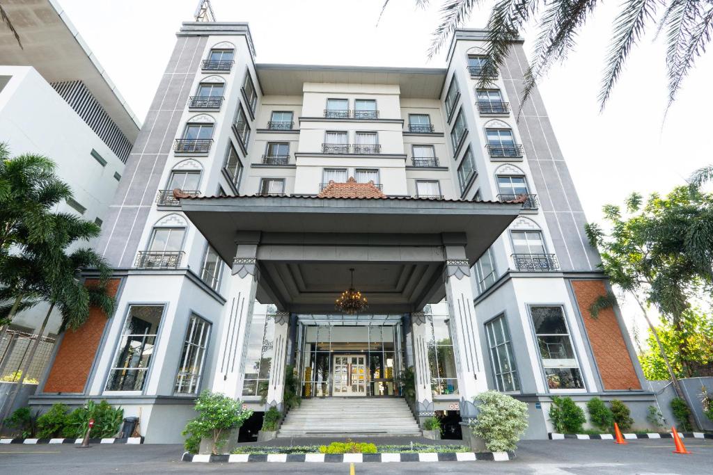 a large white building with the front entrance at Grand Serela Yogyakarta in Yogyakarta