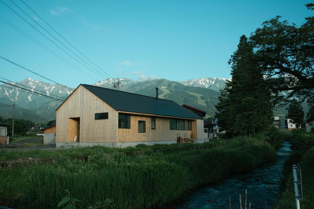 a barn with mountains in the background at JOKIJOKI Hakuba in Hakuba