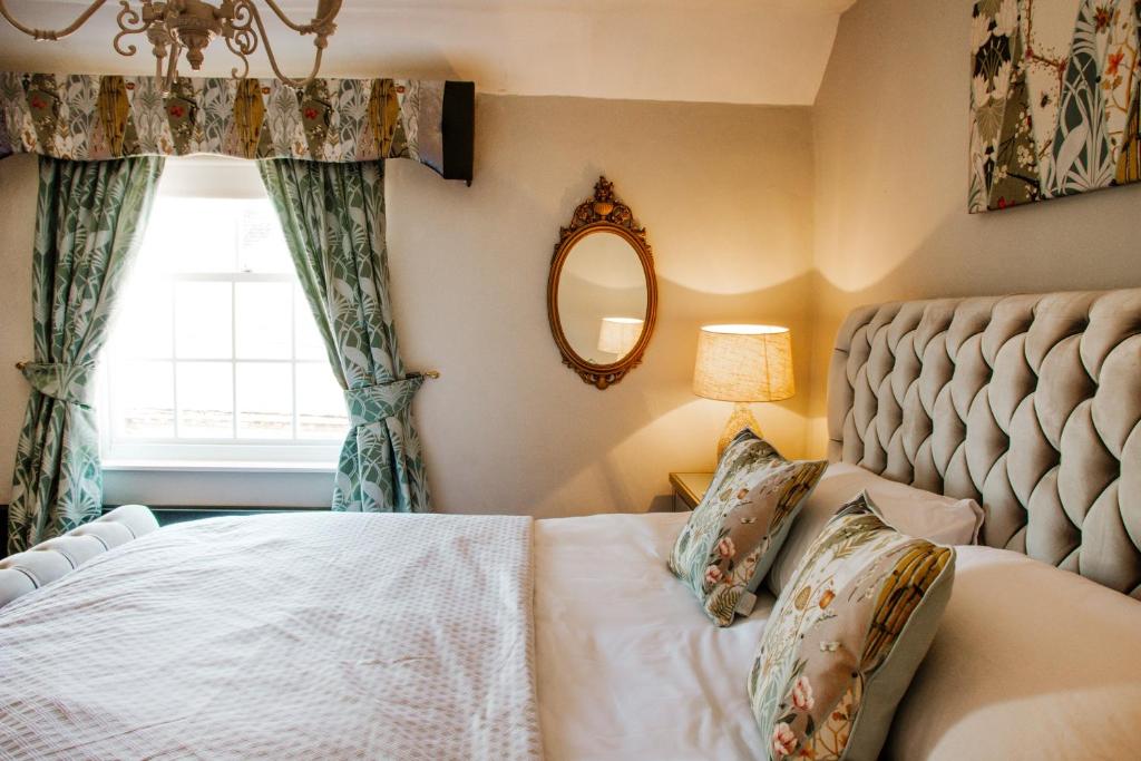 a bedroom with a bed and a mirror and a window at Whispering Place Georgian Grade II Sleeps 6 Adults 3 mins from Safari Park & Steam Train in Bewdley