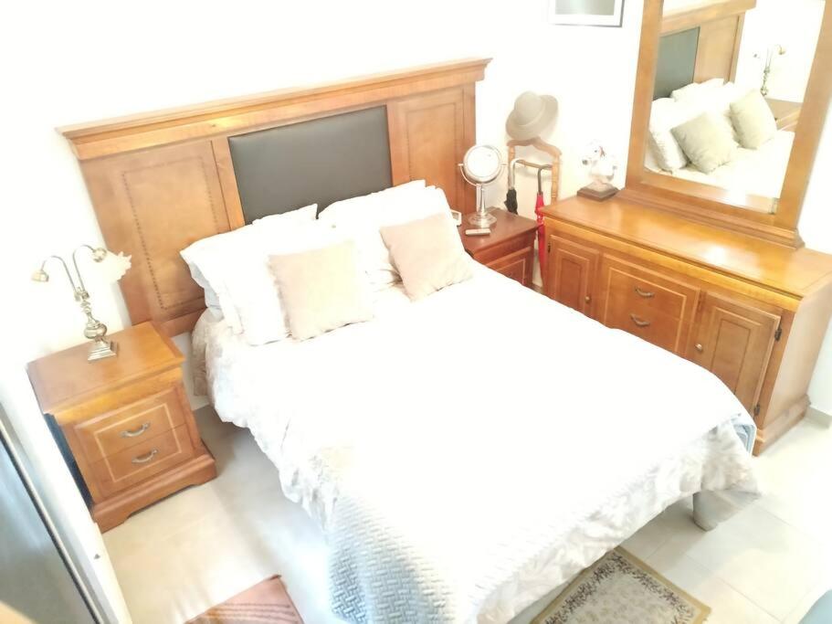 a bedroom with a white bed and a large mirror at Departamento en pueblan puebla colonial in El Gallinero