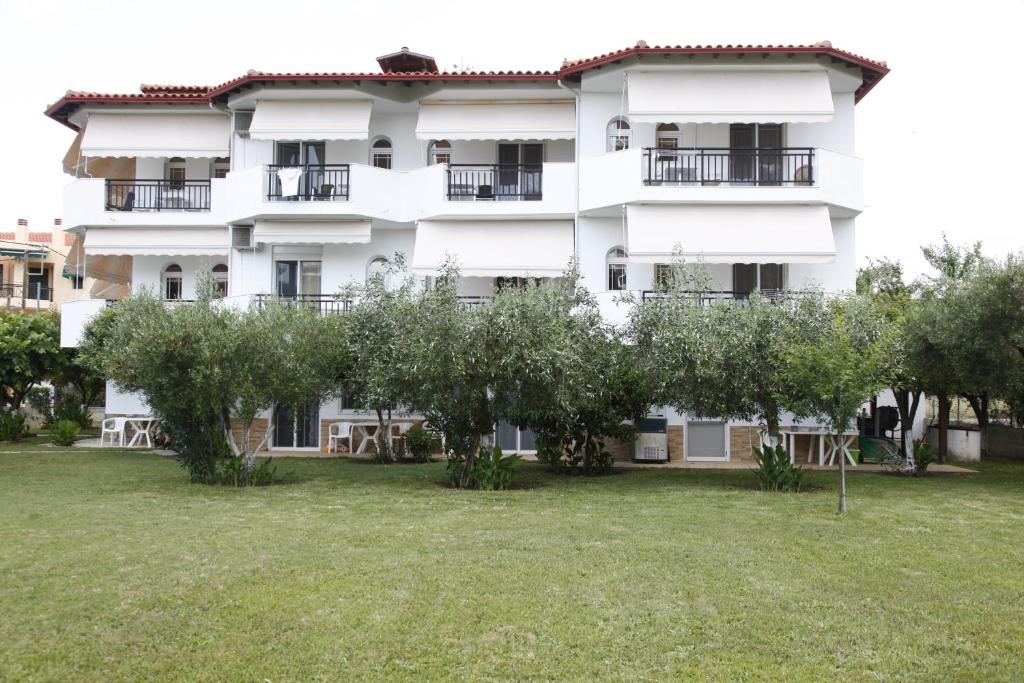 a large white building with trees in front of it at Badis Haus in Toroni