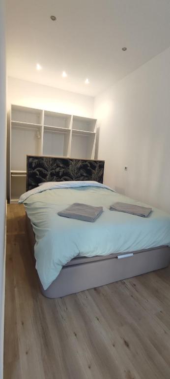 - une chambre avec un grand lit blanc et du parquet dans l'établissement La Joliette 3, à Marseille