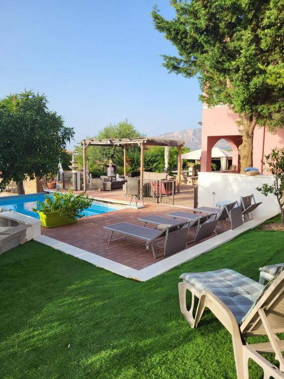 un cortile con piscina, tavolo e sedie di Villetta dei Tramonti a Trappeto