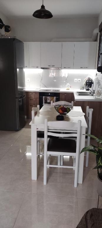 a kitchen with a table and a white table and chairs at ΠΟΛΥΤΕΛΕΣ -ΜΟΝΤΕΡΝΟ ΔΙΑΜΕΡΙΣΜΑ in Larisa