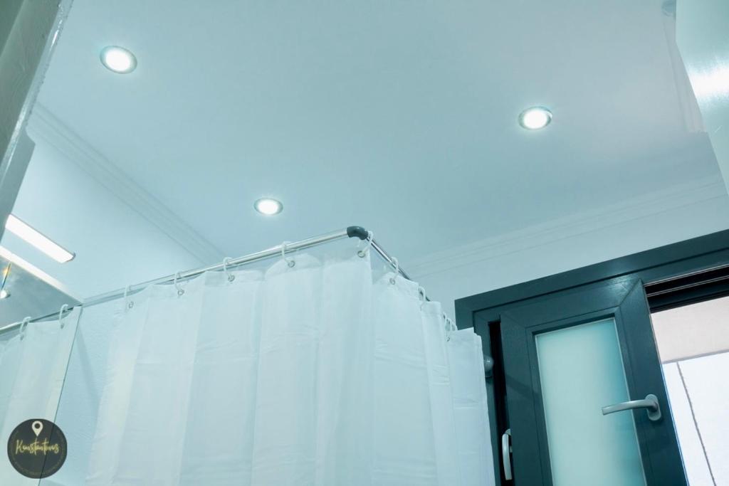 a bathroom with a white shower curtain at Seaside Apartments in Emporeios