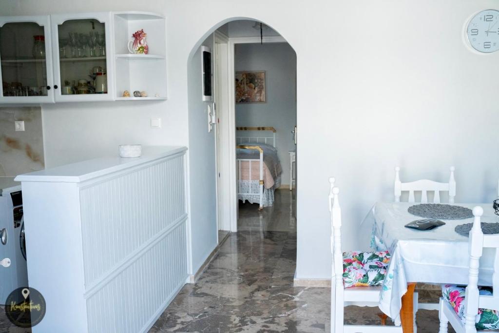 a room with a table and a kitchen with white cabinets at Seaside Apartments in Emporeios