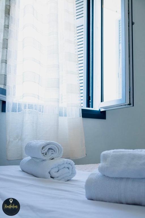 a room with a bed with towels and a window at Seaside Apartments in Emporeios