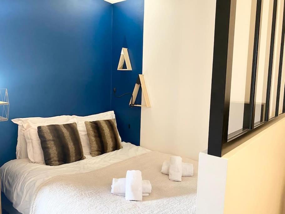 une chambre bleue avec un lit et des serviettes. dans l'établissement Balcon d'Albigny - proche lac & vue montagne, à Annecy
