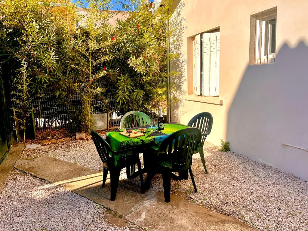 une table avec des chaises et un chiffon de table vert dans l'établissement Maison de vacance Valras-Plage, à Valras-Plage