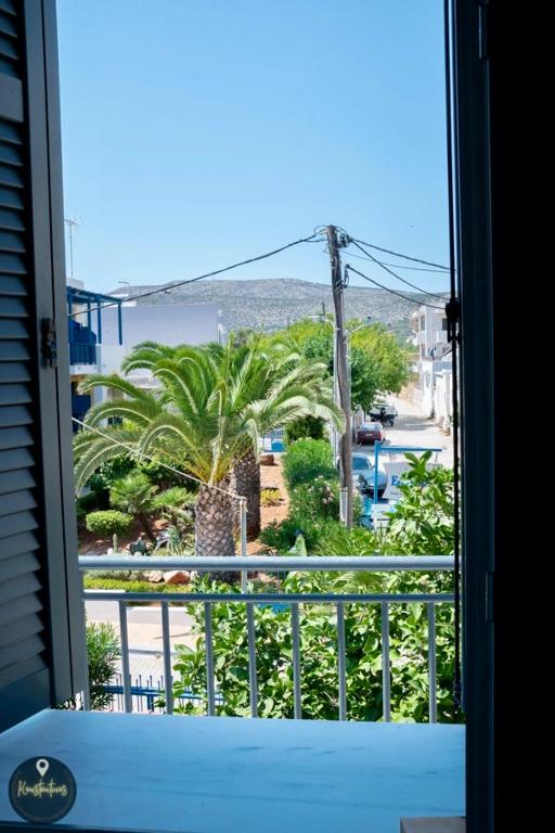 a view of a palm tree from a window at Seaside Apartments in Emporeios