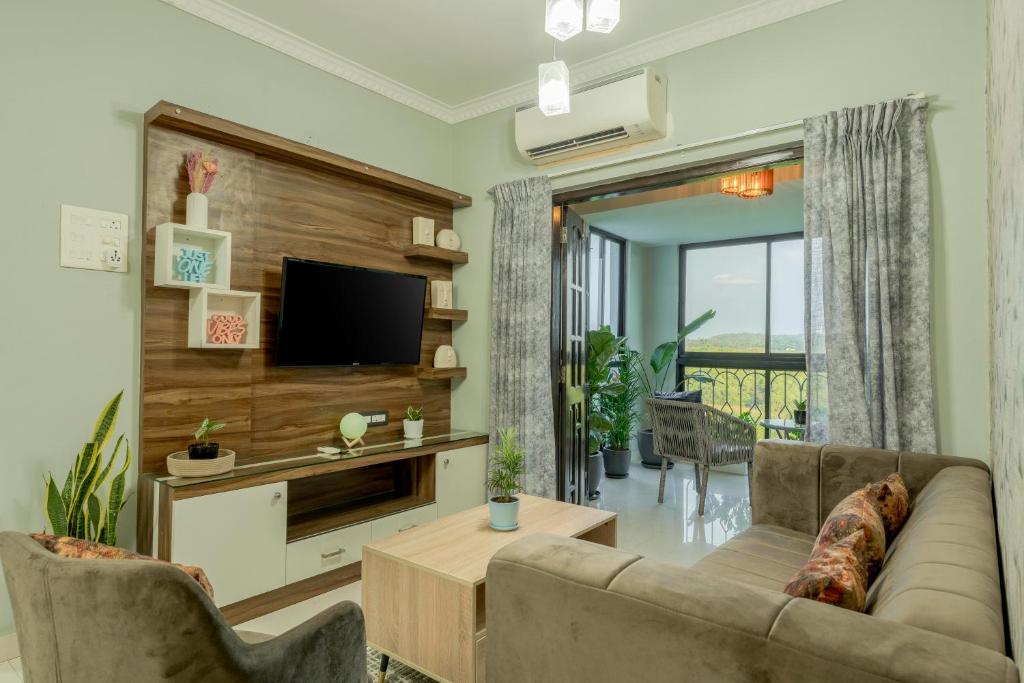 un salon avec un canapé et une télévision dans l'établissement Idyllic Abode 2 bhk apartment, à Goa