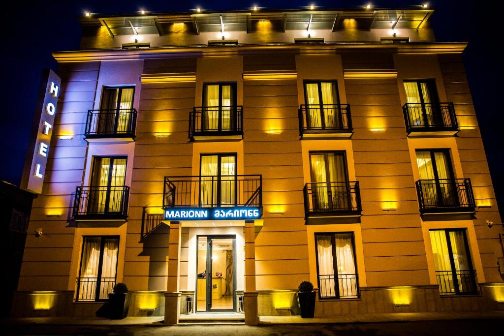 un edificio con un cartel en él por la noche en Marionn Hotel, en Tiflis