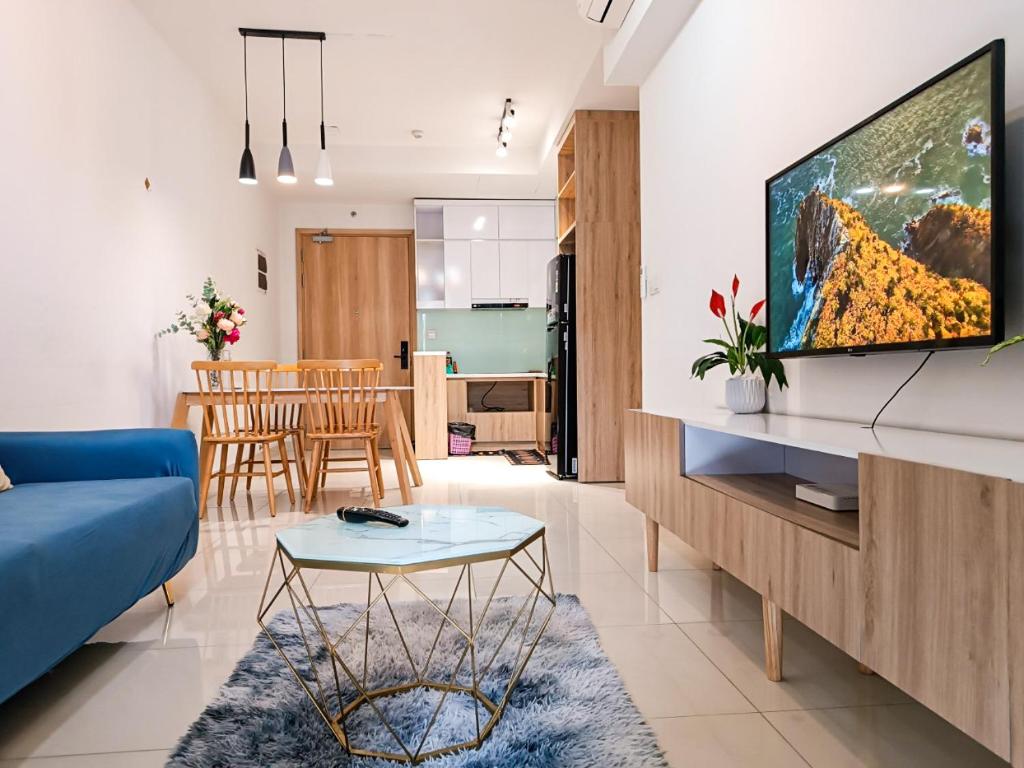 a living room with a blue couch and a tv at MIA HOMESTAY 2PN2WC cạnh Aeon Tân Phú in Ho Chi Minh City