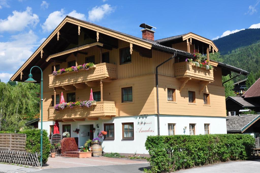 ein großes Gebäude mit Balkonen und Blumen darauf in der Unterkunft Haus Amadeus in Wagrain