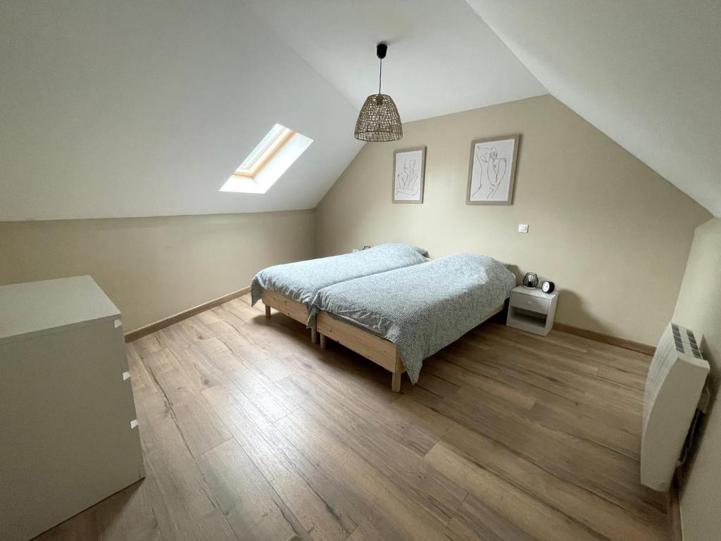une chambre avec un lit et un parquet dans l'établissement Charmante Maison indépendante au pied de la vieille ville, à Boulogne-sur-Mer