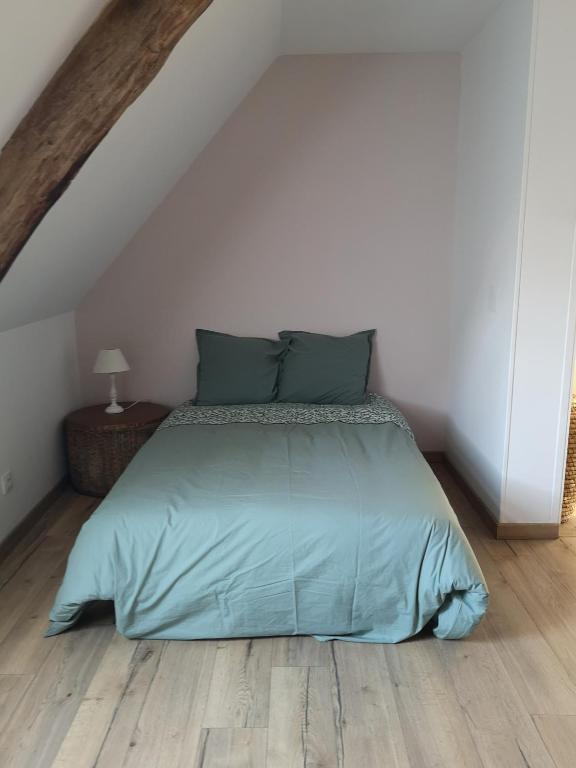 Ce lit se trouve dans une chambre blanche dotée de parquet. dans l'établissement Maison en campagne, à Meunet-Planches