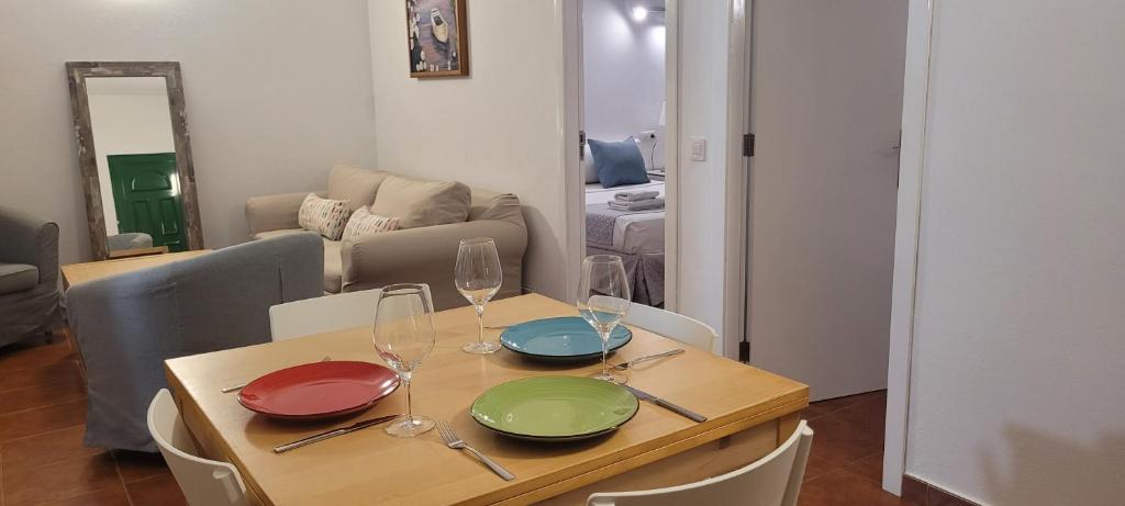 una mesa con cuatro platos y copas de vino. en Sabbia Suites El Muellito, en Famara