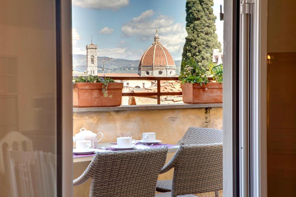 uma mesa e cadeiras numa varanda com vista para a cidade em Florence view apartment em Florença