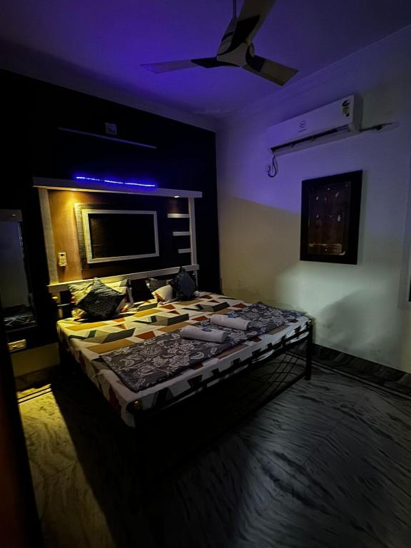 a bedroom with a bed in a room with purple lights at Rose Merry Guesthouse in Bikaner