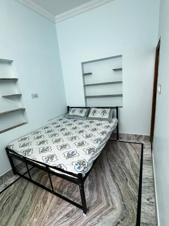 a small bedroom with a bed in a room at Rose Merry Guesthouse in Bikaner